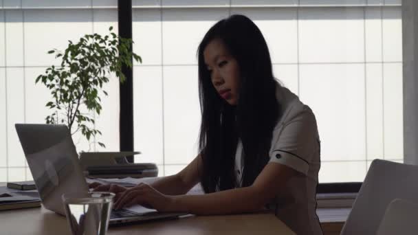 Asiática mujer de negocios trabajando en la oficina moderna en el fondo grandes ventanas — Vídeos de Stock