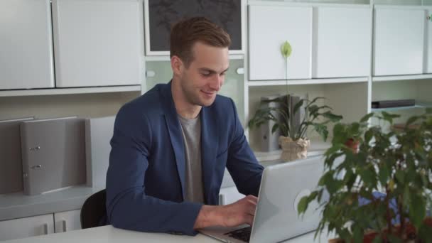 Glücklicher Geschäftsmann, der im modernen Büro am Laptop arbeitet. — Stockvideo