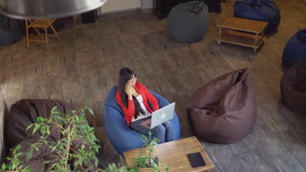 Femme dans la chambre loft avec grunge intérieur urbain en utilisant l'application sur smartphone . — Video