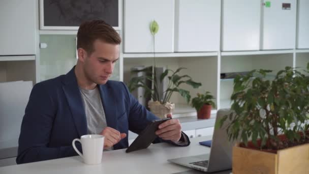 タッチ スクリーンのタブレットで読む 30 代のビジネスマン. — ストック動画