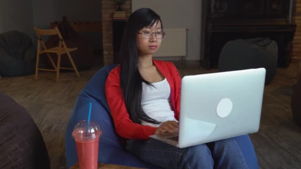Asiatische junge professionelle Frau, die am Computer arbeitet und Smoothies trinkt. — Stockvideo
