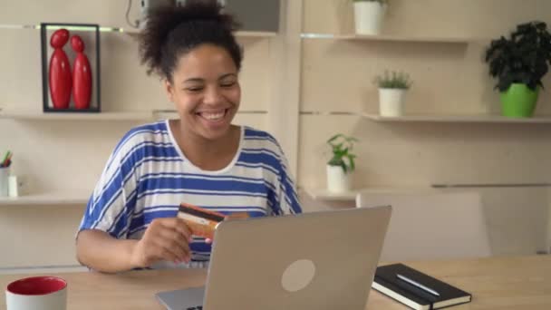 Mujer feliz bailando con tarjeta de crédito en la habitación frente a la computadora . — Vídeos de Stock