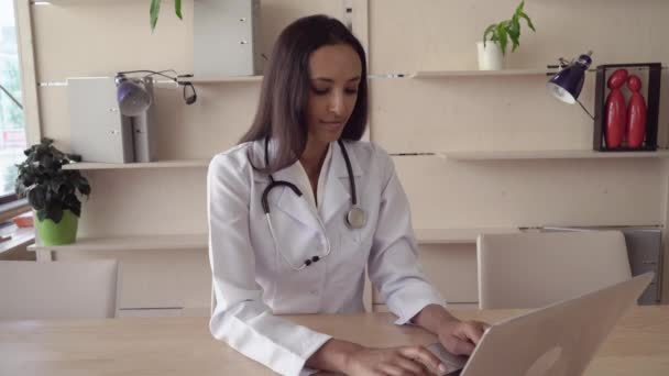 Dokter legt op de phonendoscope van de tabel camera kijken met een tevreden glimlach. — Stockvideo