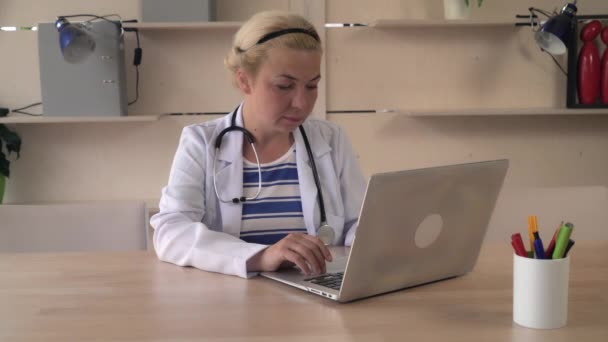 Médica sentada à mesa de madeira . — Vídeo de Stock