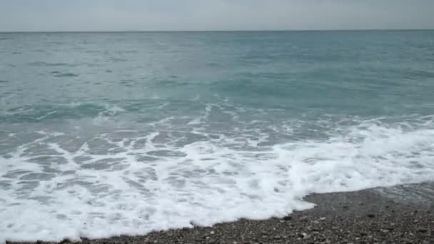 As ondas cobertas com pequenas pedras na praia — Vídeo de Stock