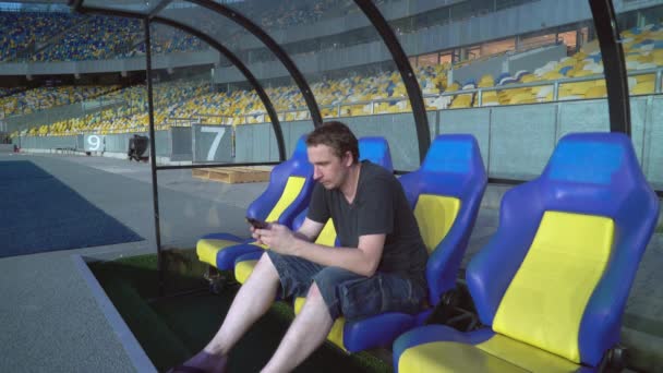 Fußballfan oder Co-Trainer plaudern vor einem Spiel im Technikbereich auf dem Handy — Stockvideo