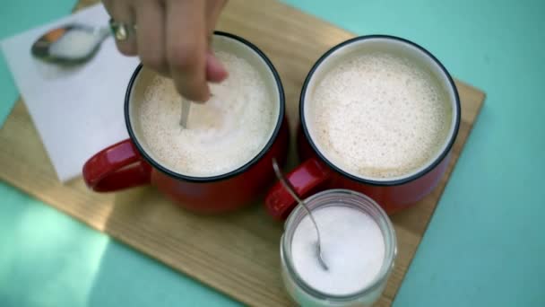 Девушки отбивают в красной чашке кофе . — стоковое видео