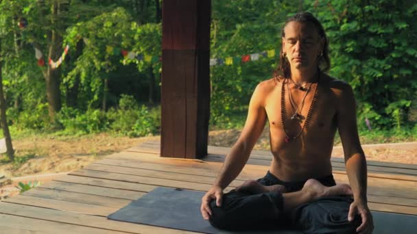 Man in de lotuspositie aangepast voor meditatie. — Stockvideo