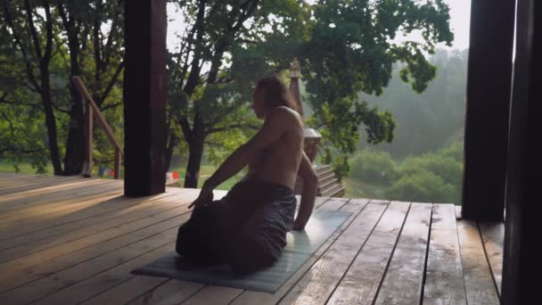 Yogui realiza ejercicio retorciéndose con las rodillas dobladas . — Vídeos de Stock