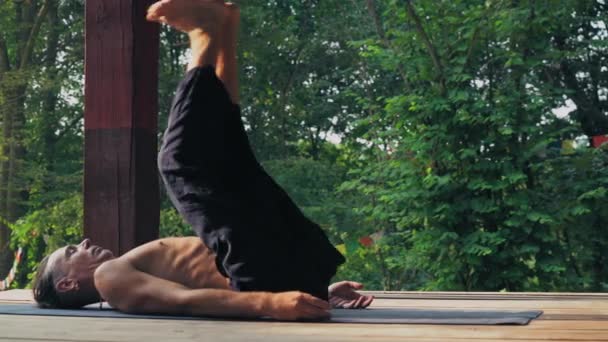 Yogi lève les jambes et baisse la tête . — Video