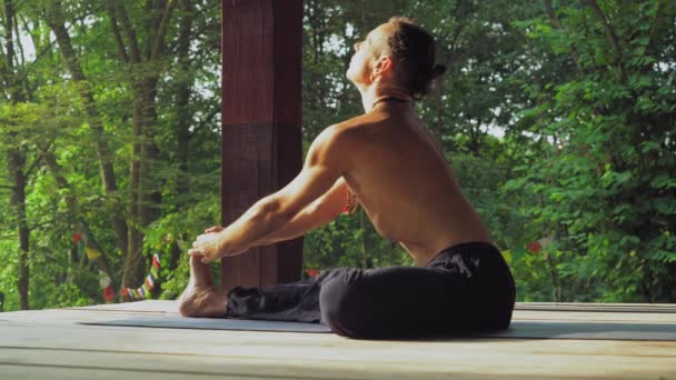 Hombre en una plataforma de madera en el parque yoga . — Vídeo de stock