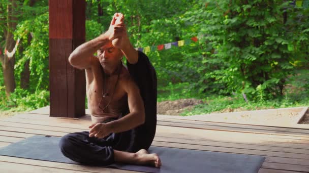 De man op de site in het park-yoga, uitvoeren van de asana 's. — Stockvideo