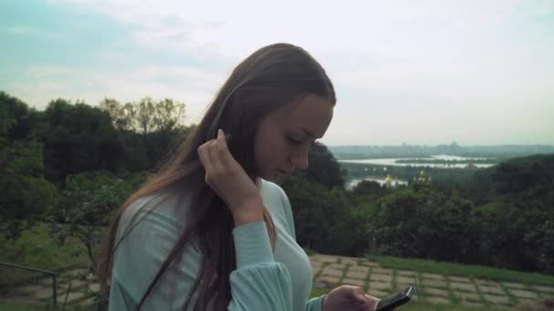 Een jong meisje is op spoor en het verkrijgen van een bericht op de telefoon. — Stockvideo