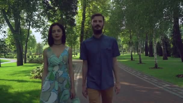 Niño y niña se acercan a la caminata en el parque . — Vídeos de Stock