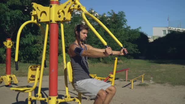 Bodybuilder trenes para principiantes al aire libre . — Vídeo de stock