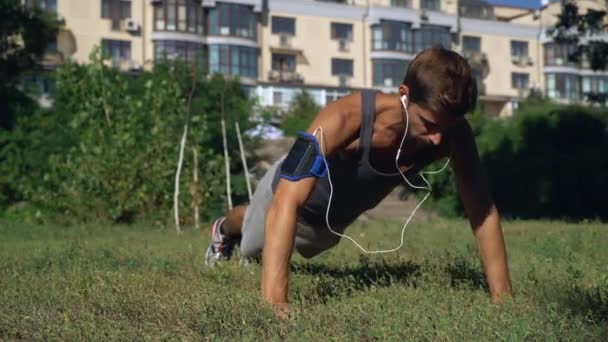 Молодий хлопчик спортсмен стиснув у парку біля будинку . — стокове відео