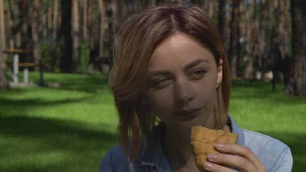 女性が野外でベーカリー製品を食べる. — ストック動画