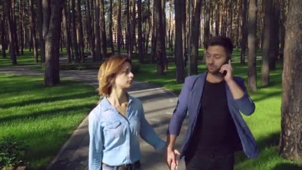 Incontri coppia nel parco. Ragazza caucasica indossa in abito casual ragazzo camicia di jeans vestito di blu giacca elegante . — Video Stock