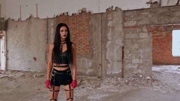 Молодая женщина носит как байкер в заброшенном доме — стоковое видео