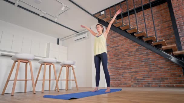 Caucasian female stretching in living room — Stockvideo