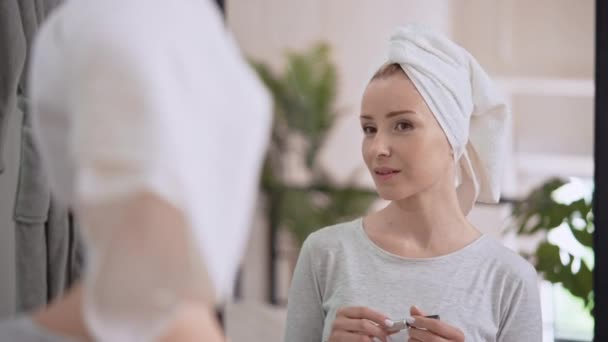 Vrouw aanbrengen make-up op het gezicht thuis — Stockvideo