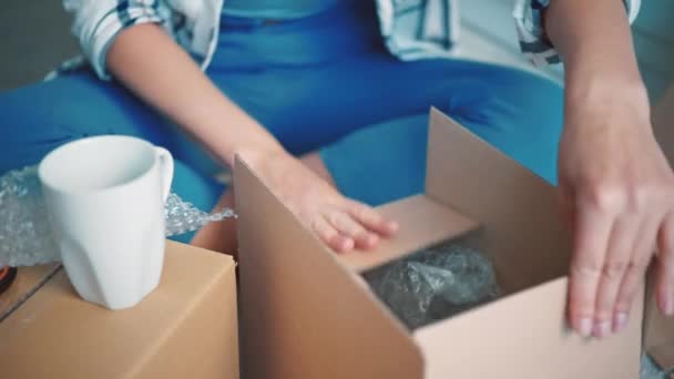 Weibchen packen Gegenstand in Wohnung ein — Stockvideo