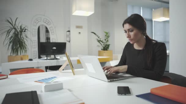 Atrakcyjny biznes kobieta pracuje w biurze i patrząc na zdjęcie ramki — Wideo stockowe