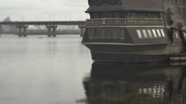 Kleine vissersboot verankerd in de rivier naast een brug. Schepen in de haven van. — Stockvideo