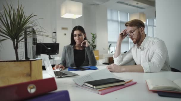 Mitarbeiter diskutieren über die Arbeit im Büro. Gemeinsam auf Laptop schauen — Stockvideo