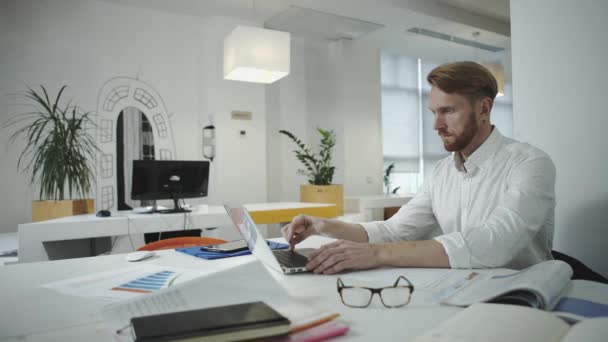 Attraktiver Geschäftsmann, der im Büro arbeitet und Fotorahmen betrachtet — Stockvideo