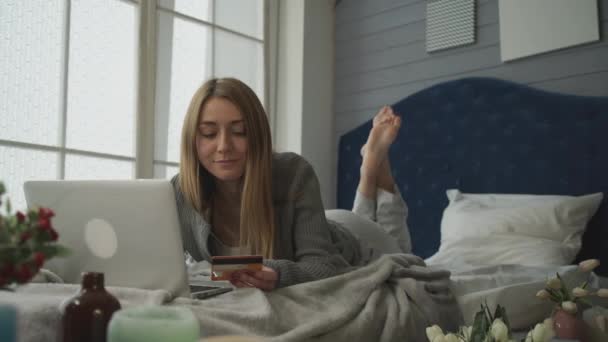 Blond w łóżko rezygnować pewien laptop wydaje pieniądze. — Wideo stockowe