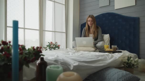 Desayuno en el hotel, la chica que trabaja con el ordenador portátil — Vídeo de stock