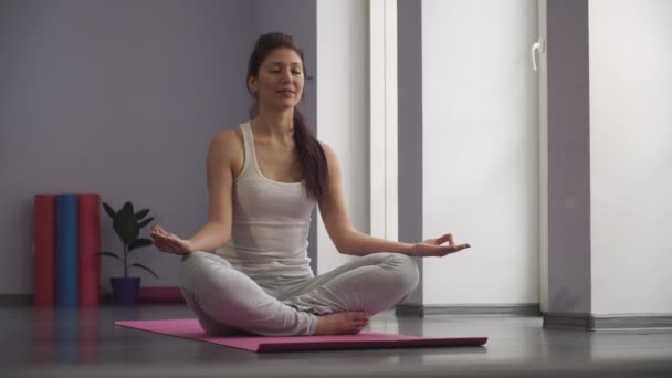 Yoga-Mädchen meditiert und macht mit ihrer Hand ein Zen-Symbol. — Stockvideo