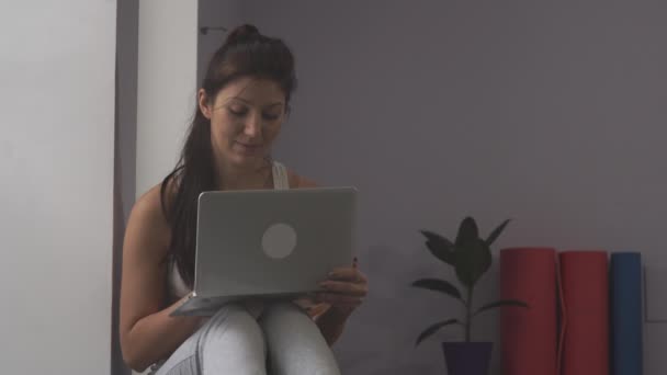 Vrouw l met een laptop in de sportschool — Stockvideo