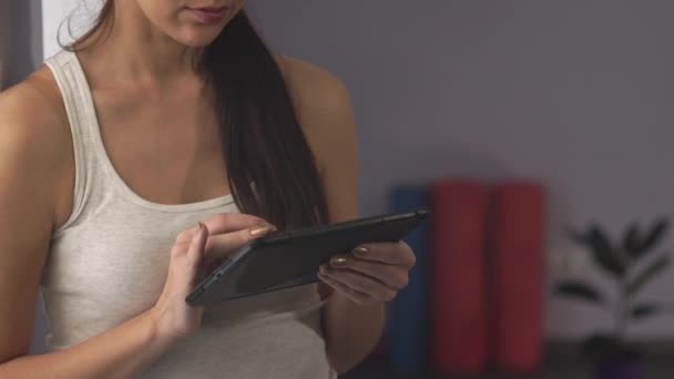 Mulher com um tablet está no ginásio — Vídeo de Stock