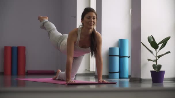 Женщина делает упражнения для ног на ковриках для упражнений — стоковое видео