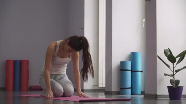 Mujer sentada en la alfombra y haciendo ejercicios relajantes — Vídeos de Stock