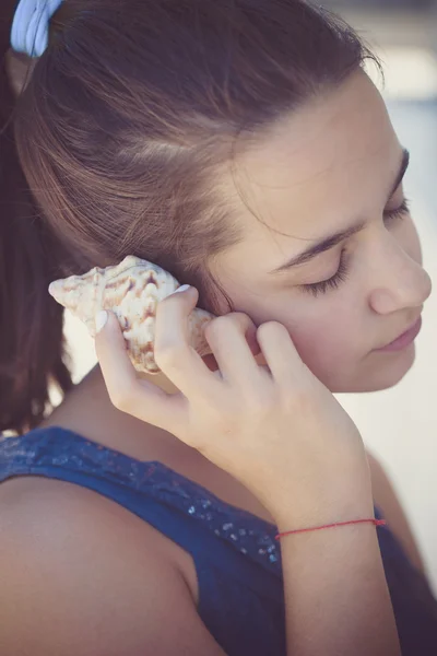 Tiener meisje Luister sea shell — Stockfoto