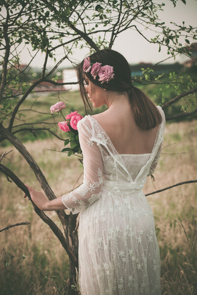 young woman in white dress by tree