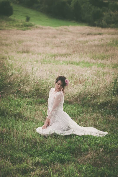 Jonge vrouw in witte kanten jurk op weide — Stockfoto