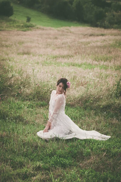 Giovane donna in abito di pizzo bianco sul prato — Foto Stock