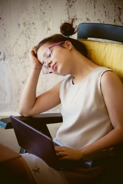 Tired girl in front of laptop — Stock Photo, Image