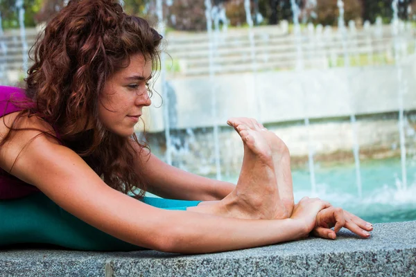 Giovane donna pratica yoga all'aperto — Foto Stock