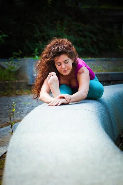 Mujer joven practica yoga al aire libre — Foto de Stock