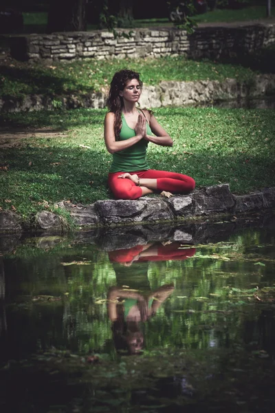 Mujer joven practica yoga al aire libre — Foto de Stock