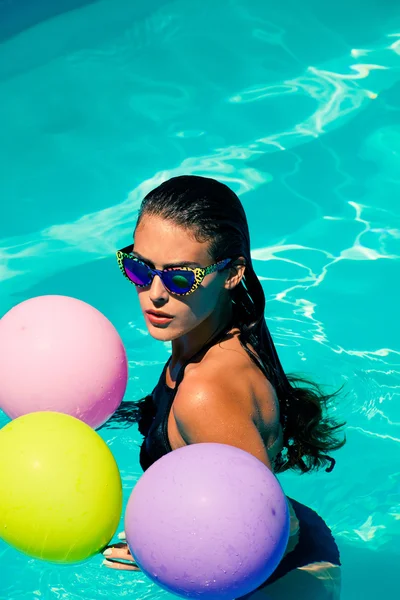 Женщина в бассейне с воздушными шарами — стоковое фото