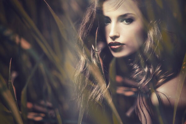 Beautiful long hair brunette woman portrait, double exposure with blades of grass