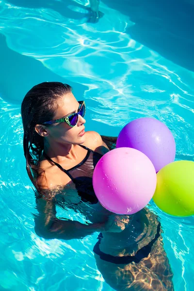 Frau mit Luftballons am Pool — Stockfoto