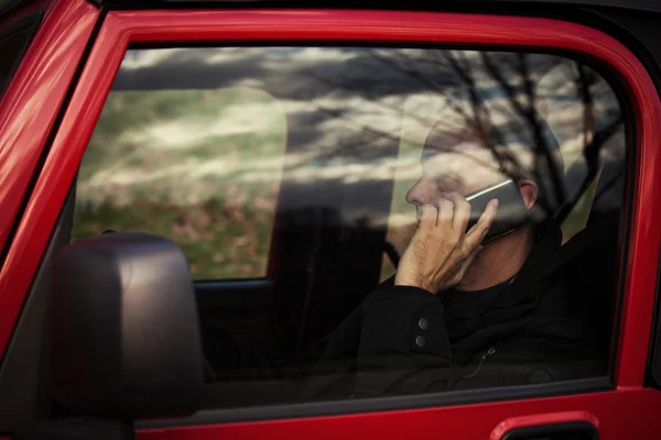 Hombre con teléfono móvil en coche — Foto de Stock