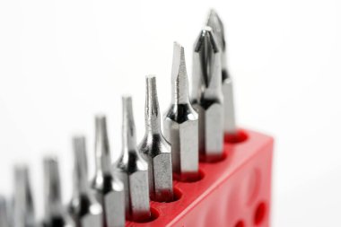 Kırmızı kutudaki alet çeliğinden yapılmış tornavida parçaları stüdyoda beyaz bir arkaplanda fotoğraflanmış.                     